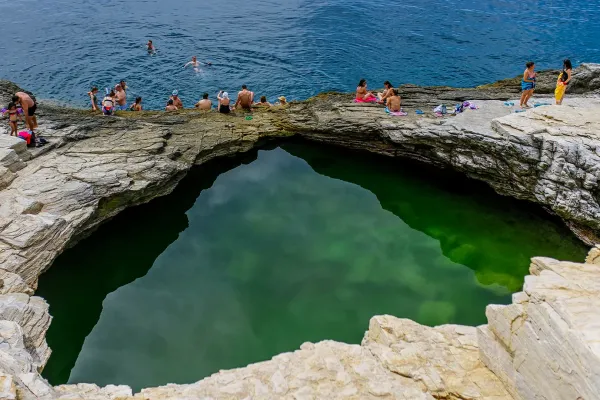 close-up-view-of-giola-lagoon-in-thassos-with-its-emerald-green-waters-reflecting-the-light-surrounded-by-natural-rock-formations677CFDDE-002C-E559-E25A-FD41A8E55BCF.webp